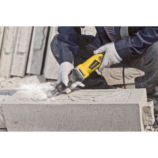 STANLEY STEL861 angle grinder used for stone carving, close-up in workshop.