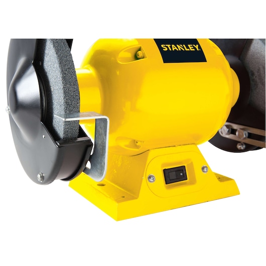 STANLEY STGB3715 bench grinder side angle, yellow body with protective guard on grinding wheel.