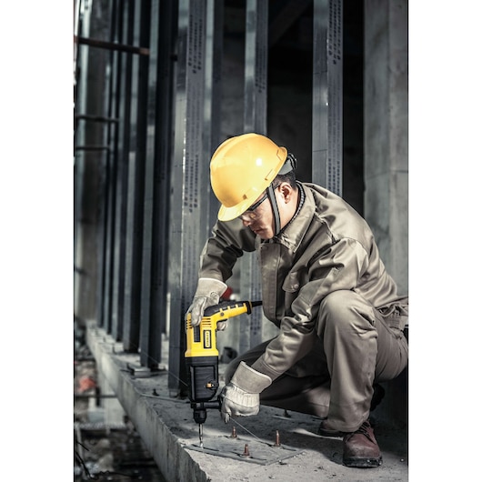 STANLEY STHR202K rotary hammer drill used on concrete by worker in safety gear at construction site.