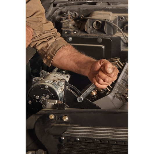 ANTISLIP WRENCH 9/16"STANLEY  MECHANICAL WORKSHOP FRONT CLOSE UP OF A HAND ADJUSTING A PIECE OF THE MOTOR WITH WRENCH