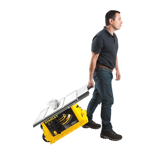 STANLEY STST1825 portable table saw, yellow and black, being carried by a person, side angle.